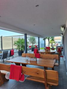 a patio with wooden tables and chairs with red napkins at Hotel Hohenloher Tor in Bretzfeld