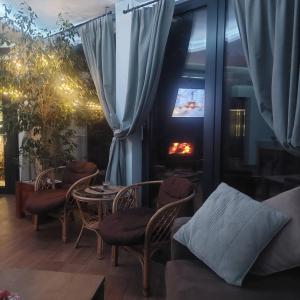 a living room with a table and chairs and a fireplace at Apartman Jovanic in Divčibare