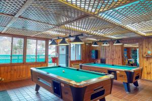 two pool tables in a room with wooden walls at Loon Mountain Nest in Lincoln