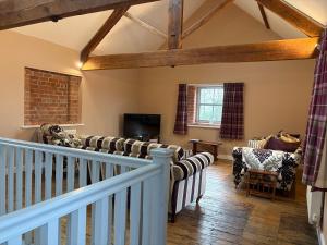 a living room with couches and a tv at The Granary, Wolds Way Holiday Cottages, spacious 3 bed cottage in Cottingham