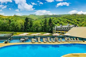 a large swimming pool with chairs and umbrellas at Loon Mountain Nest in Lincoln