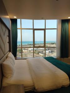 a large bed in a room with a large window at همم للشقق المخدومة أملج-HMM Appartment Service in Umm Lajj +48 photos