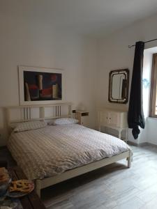 ein Schlafzimmer mit einem Bett und einem Spiegel an der Wand in der Unterkunft La Barabbata in Marta
