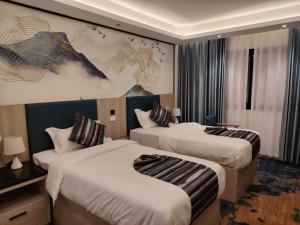 ein Hotelzimmer mit zwei Betten und einem Gemälde an der Wand in der Unterkunft Marigold Tripoli hotel فندق ماري قولد in Tripoli