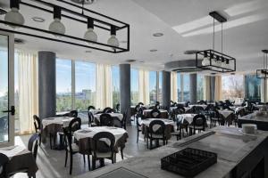 a restaurant with tables and chairs and large windows at Hotel ABA FRONTE MARE in Milano Marittima