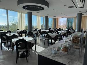 a dining room with tables and chairs and windows at Hotel ABA FRONTE MARE in Milano Marittima +35 photos