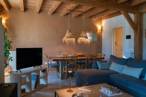 a living room with a blue couch and a table at Can Buch ECOHotel Boutique & SPA in Sant Aniol de Finestras