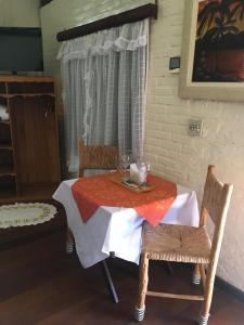 a table with a red and white table cloth on it at Passarim Chalé in Monte Verde