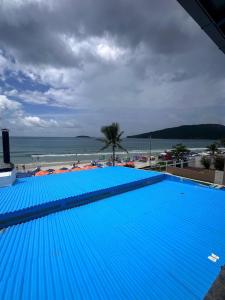 a large blue swimming pool next to a beach at Vista Beach Ingleses in Florianópolis