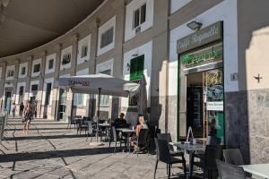 a group of people sitting at tables outside a building at L'Arnia in Naples