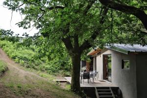 a house with a porch with a table and a tree at Lodge La Clède in Concoules