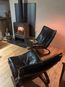 a leather chair in a living room with a fireplace at Lodge La Clède in Concoules