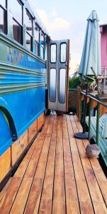 an open door of a bus with a table and an umbrella at El Destino - Rooftop Converted Chicken Bus in San Marcos La Laguna