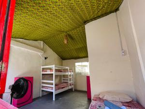 a room with two bunk beds and a ceiling at Colombia Hostel in Porto Seguro