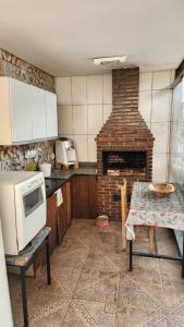 a kitchen with a brick fireplace and a table with a microwave at Alure 1 in Belo Horizonte