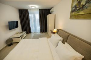 a hotel room with a bed and a couch at Le Blanc ApartHotel in Bucharest