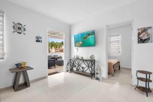 a white living room with a bedroom and a table at Bay View by Otium in Catano