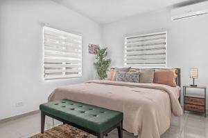 a bedroom with a large bed with a green bench at Bay View by Otium in Catano