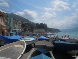 a beach with blue umbrellas and people on the beach at I ciottoli di Bogliasco in Bogliasco