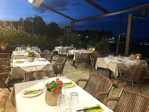 a restaurant with white tables and chairs and tablesearcher at Χρυσοπελεια - Chrisopeleia Lake View in Neochori +52 photos