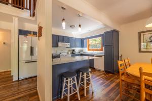 a kitchen with blue cabinets and a table and chairs at Casa La Playa - Duck, Sanderling, Lakefront, 160 Yards to the Beach, Community Pool, Pets OK in Duck