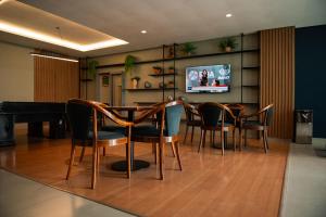 a dining room with a table and chairs and a piano at Hotel Serrano in Campina Grande