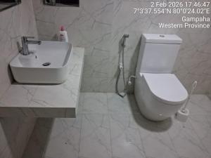 a bathroom with a white toilet and a sink at Slayan-1 properties in Mudungoda