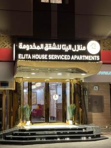 a building with a sign that reads elka house serviced apartments at درة الينا للشقق المخدومة in Ar Rabwah