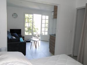 a bedroom with a bed and a living room at Le repos des crêtes in Cavalaire-sur-Mer