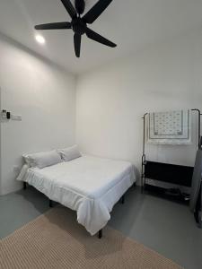 a bedroom with a bed with a ceiling fan at Deyrina Home in Arau