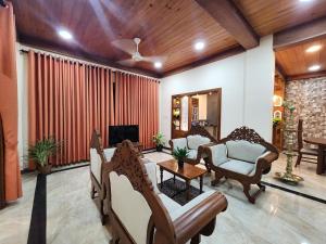 a living room with a couch and a tv at Mahizh Manai in Jaffna