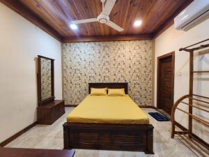 a bedroom with a bed and a ceiling fan at Mahizh Manai in Jaffna +50 photos