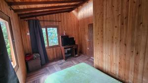 a room with a bed and a television in a cabin at Aitana Mágica in Copacabana