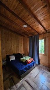 a bedroom with a bed in a wooden cabin at Aitana Mágica in Copacabana