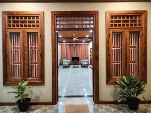 a hallway with doors and plants in a building at Mahizh Manai in Jaffna