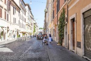 a woman sitting on a bench on a cobblestone street at Vaticano luxury sleep in Rome