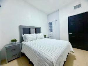 a bedroom with a white bed with a black door at Casa Marsella Privada y Moderna 1 in Zaragoza