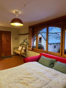 a bedroom with a bed and a large window at La Dimora della Fontana in Mozzio