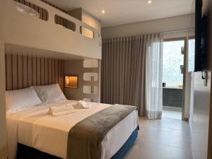 a bedroom with a large bed and a television at Ágape Hotel in São Sebastião +56 photos