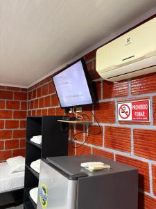 a room with a tv on a brick wall at ECORAUDAL posada campestre in San José del Guaviare