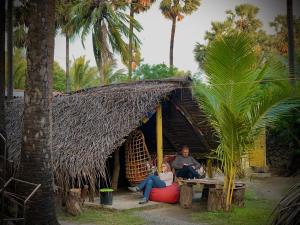 a man and a woman sitting outside of a hut at Delft Village Stay - Experience Based Local Island Stay in Jaffna in Delft East +128 photos