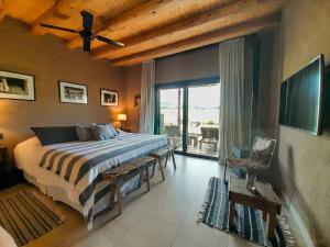 a bedroom with a bed and a large window at Rancho Adobe Eco Hotel in Tupungato