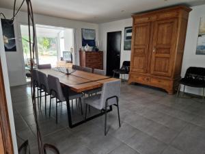 a dining room with a wooden table and chairs at Villa Nelson Classée 3 étoiles in Moliets-et-Maa