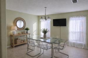 a dining room with a glass table and a television at Fresh Crash Pads 4-Affordable Shared Housing in Houston