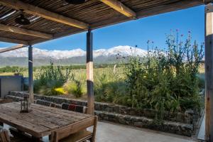 a patio with a table and mountains in the background at Rancho Adobe Eco Hotel in Tupungato