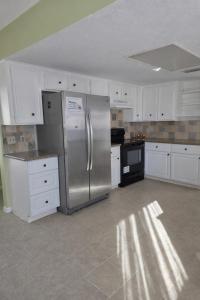 a kitchen with a stainless steel refrigerator and white cabinets at Fresh Crash Pads 4-Affordable Shared Housing in Houston
