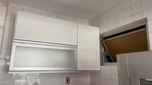 a white cabinet in a kitchen with a window at Izabelly Andrade in Recife