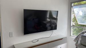 a flat screen tv hanging on a white wall at Izabelly Andrade in Recife