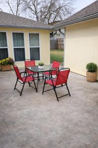 a patio with a table and four red chairs at Fresh Crash Pads 4-Affordable Shared Housing in Houston