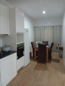 a kitchen and dining room with a table and chairs at T&S Guest House in Praia